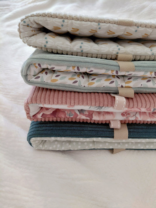 Photo de quatre pochettes à livre en velours côtelé, de couleur vert, rose, bleu ou beige avec leur intérieur assorti