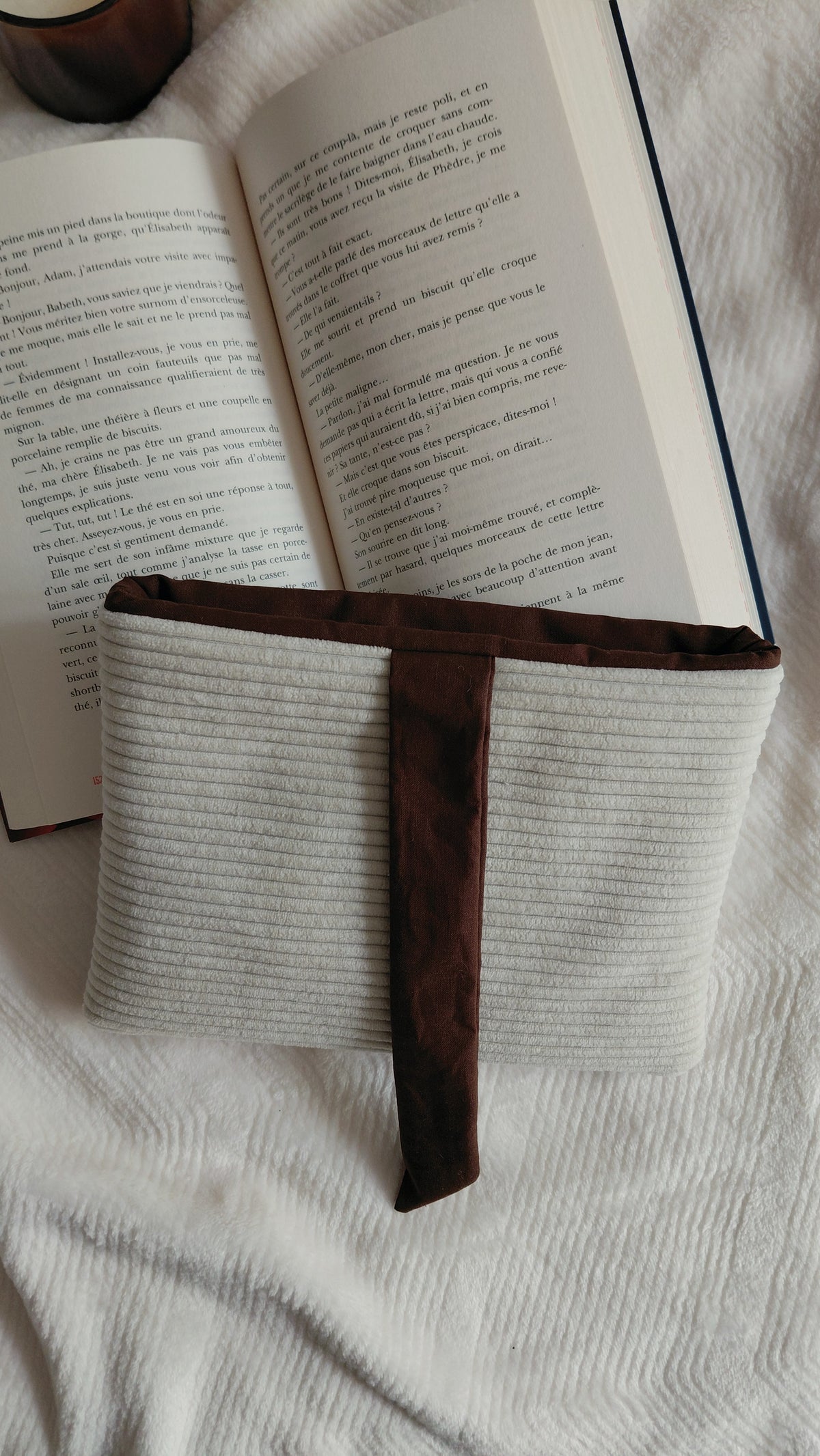 Pochette à livre format poche de la collection automne. Exterieur en velours côtelé écru et intérieur en coton couleur chocolat. Molletonnée, elle est parfaite pour emmener ses lectures partout avec soi sans les abîmer. 