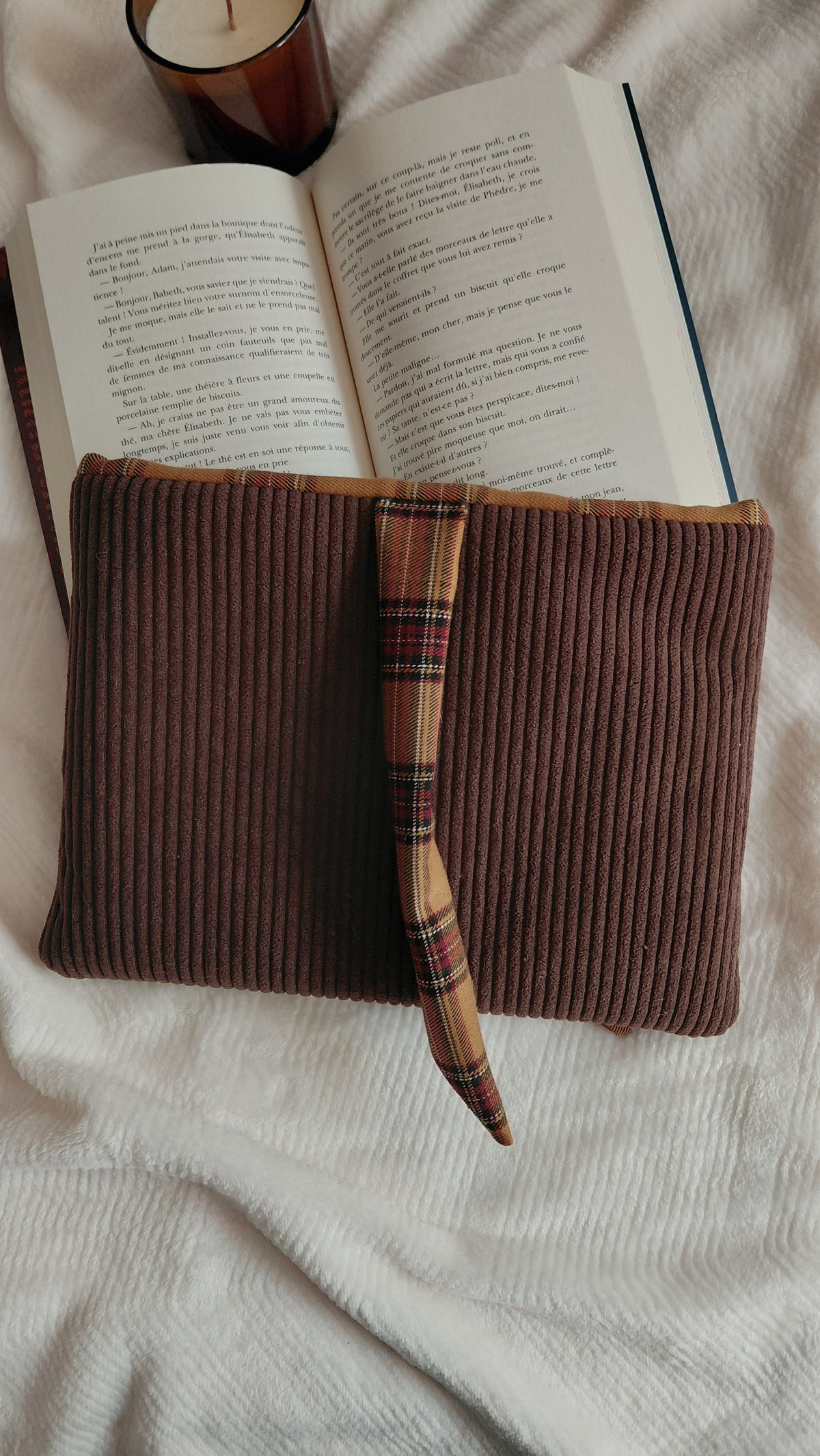 Pochette à livre format broché de la collection Automne, en velours côtelé chocolat et intérieur en tartan marron. Permet d'emmener ses lectures partout sans les abîmer. 