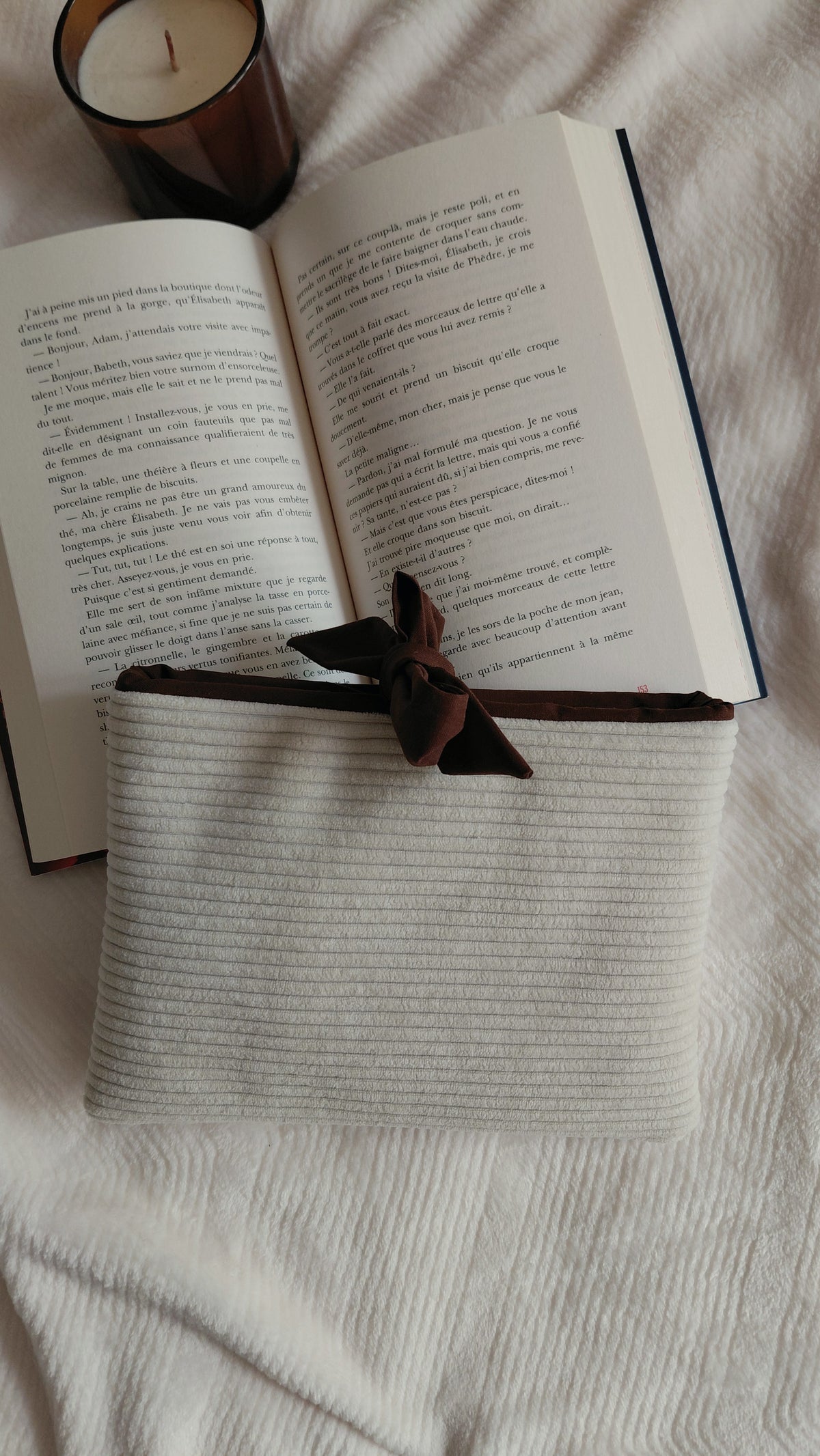 Pochette à livre format poche de la collection automne. Exterieur en velours côtelé écru et intérieur en coton couleur chocolat. Molletonnée, elle est parfaite pour emmener ses lectures partout avec soi sans les abîmer. 