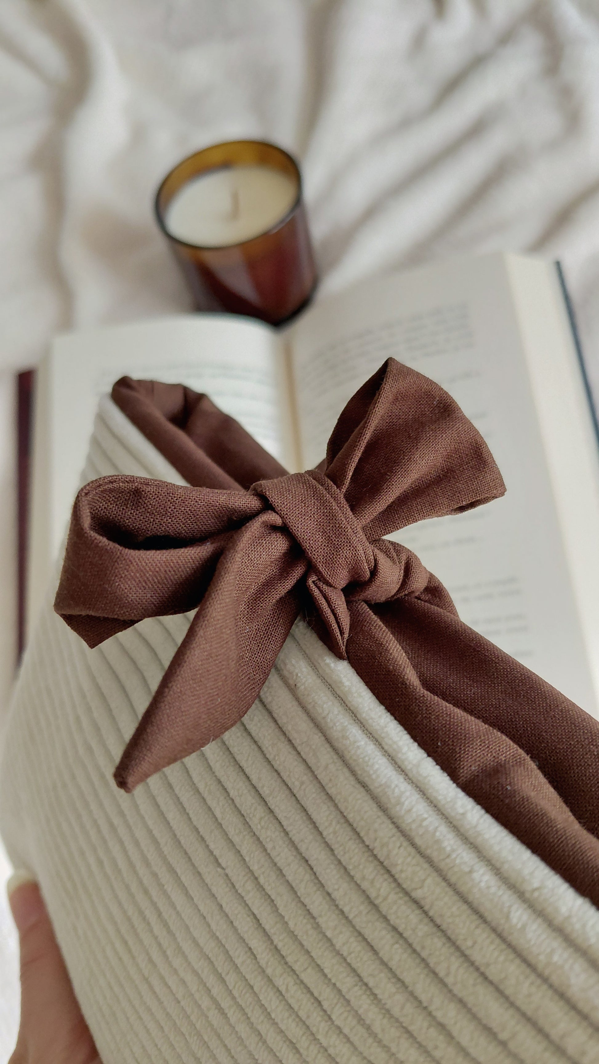Pochette à livre format poche de la collection automne. Exterieur en velours côtelé écru et intérieur en coton couleur chocolat. Molletonnée, elle est parfaite pour emmener ses lectures partout avec soi sans les abîmer. 